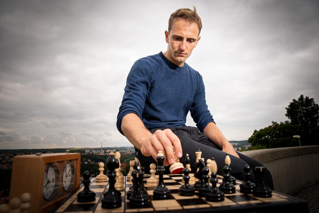 Ondřej Perušič sedí na zídce, hraje šachy s výhledem na město