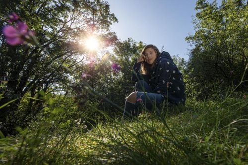 Eva Samková sedí v trávě v přírodě