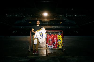 Roman Bernat stojí uprostřed hokejové haly u bránky s hokejovými dresy Kladno, České Budějovice, česká reprezentace