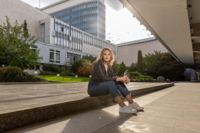 Barbora Černošková sedí na obrubníku mezi budovami