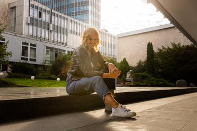 Barbora Černošková sedí na obrubníku mezi budovami